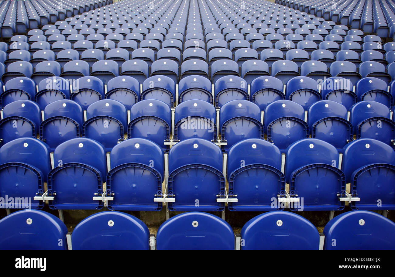 Numbered rows of empty blue seats in a sporting arena or stadium Stock Photo
