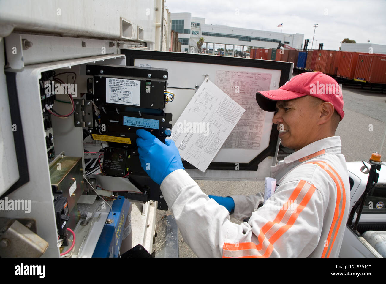 Oakland California A maintenance worker repairs a refrigerated shipping container in the Port of Oakland Stock Photo