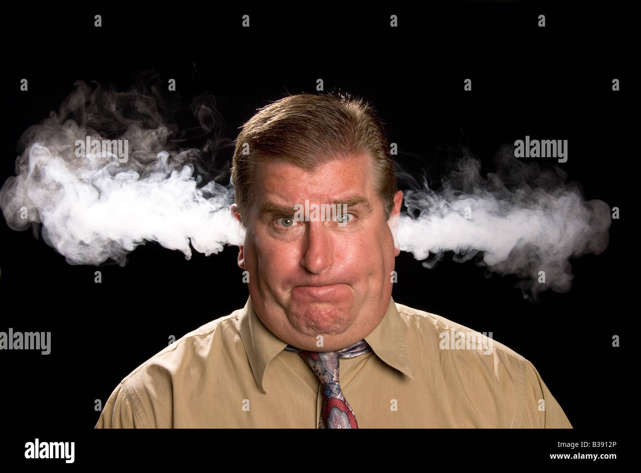 A man is angry and venting smoke from his ears in a classic expression shared in illustrations and cartoons Stock Photo
