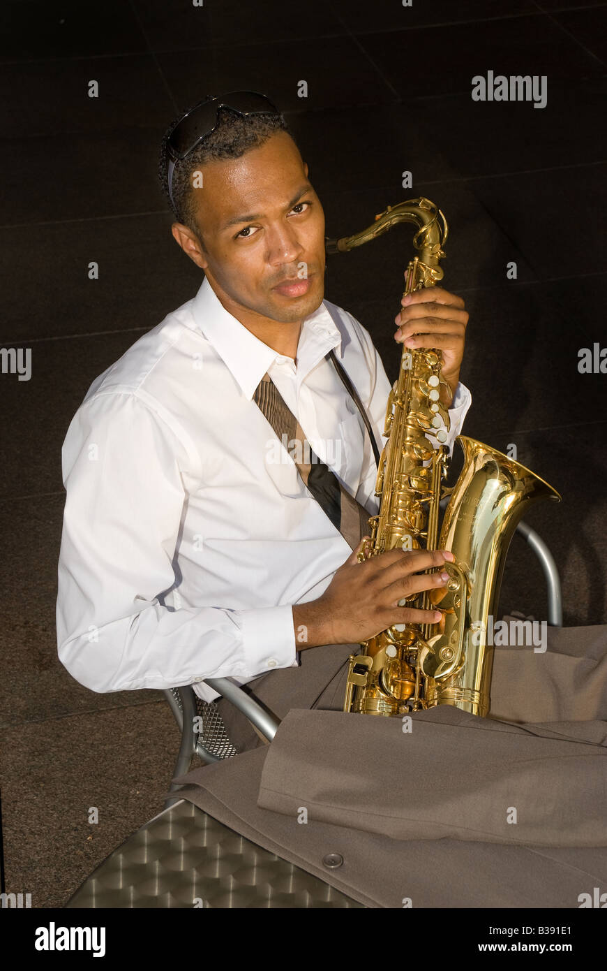 A saxophone player rests between songs Stock Photo