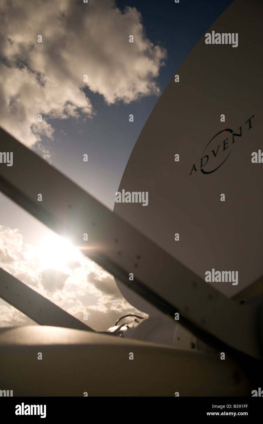 close up of an Advent satellite uplink dish with sun bursting over support arms Stock Photo