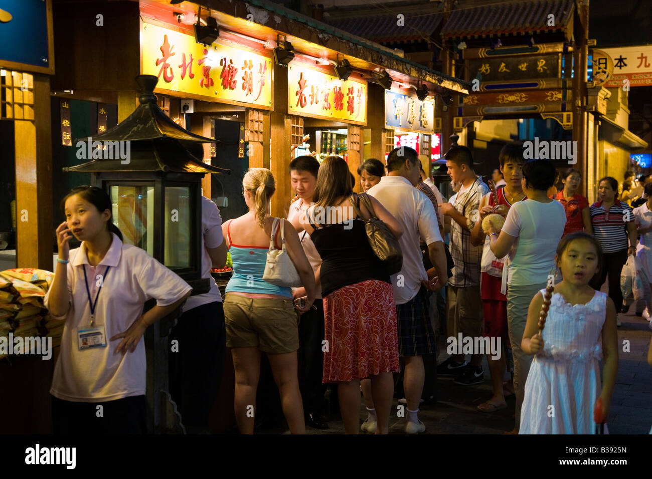 Chinese and foreigners mingle at food stall in Wanfujing Dajie Street Beijing's main shopping street at night JMH3188 Stock Photo