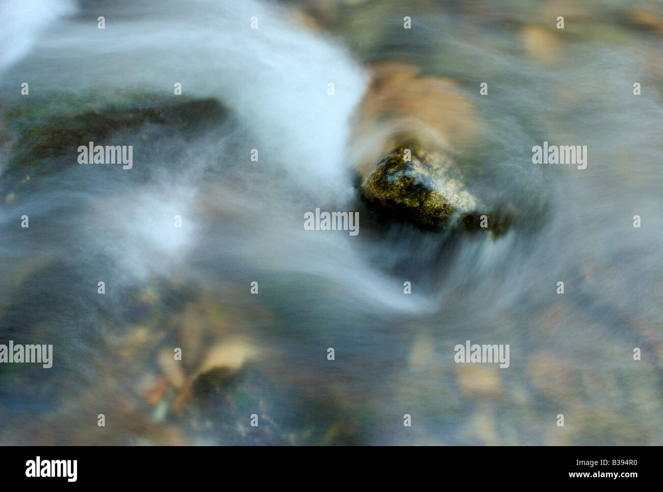 Detail of stream flowing around a stone Stock Photo - Alamy
