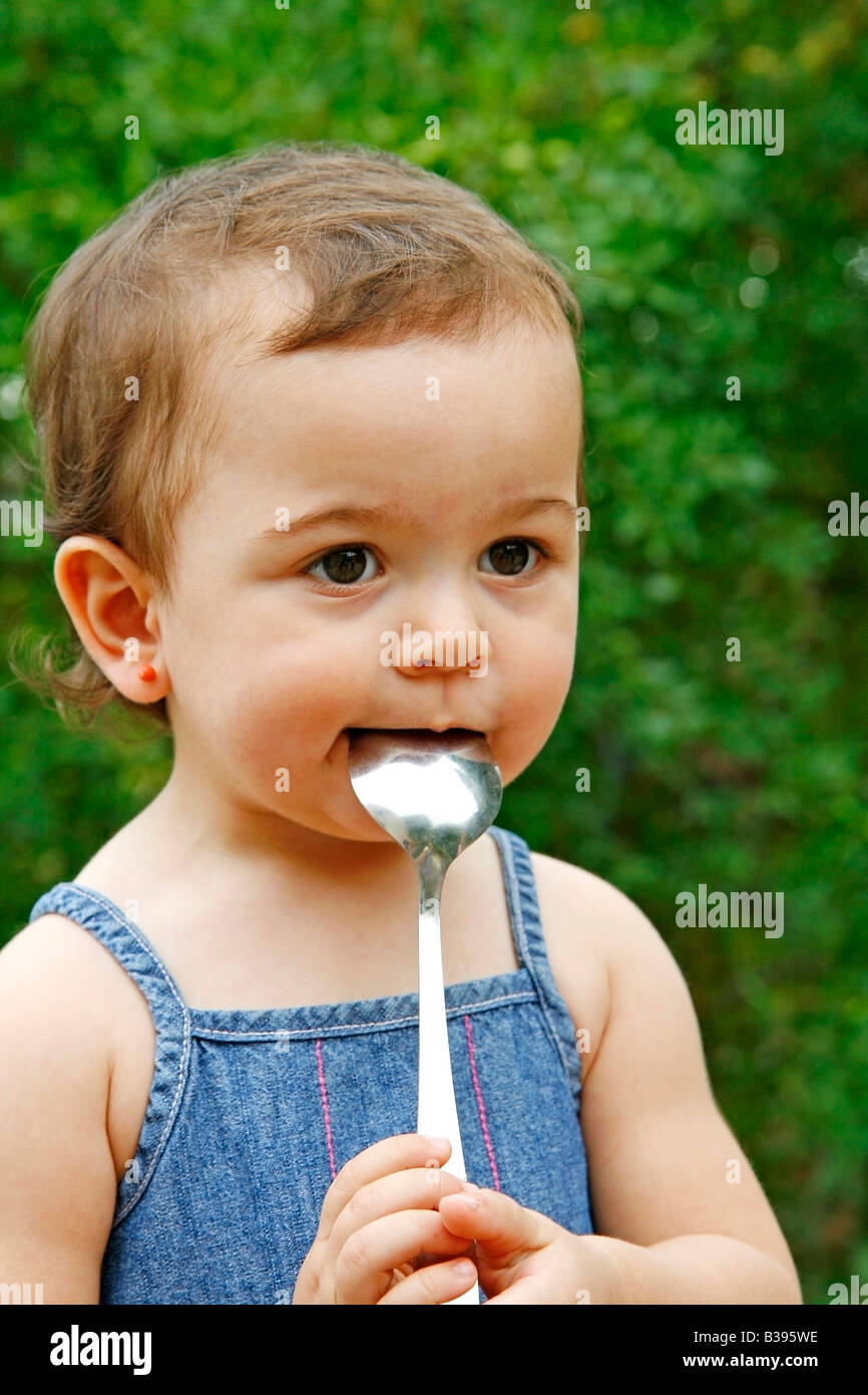 Baby and spoon in mouth Stock Photo