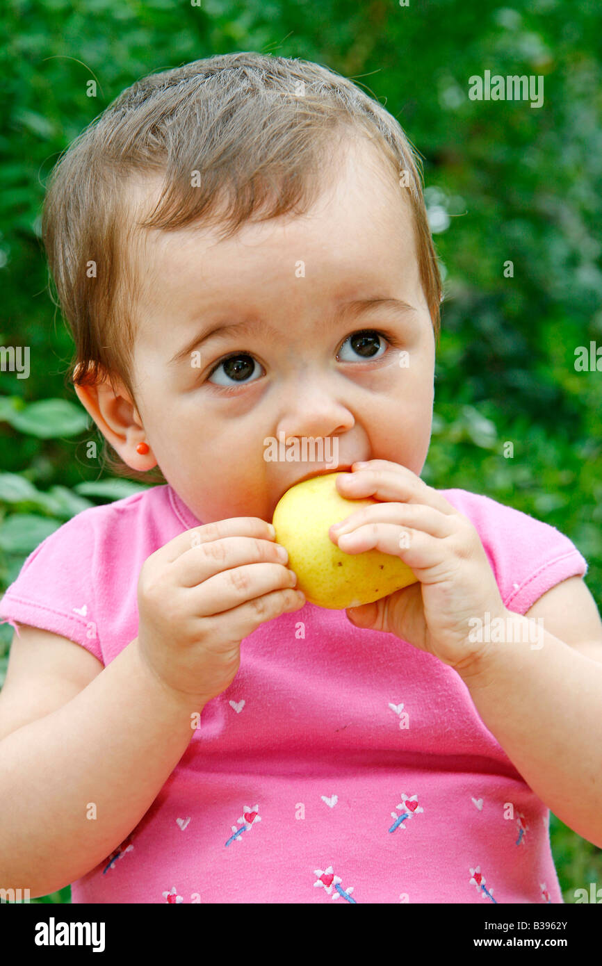 Baby eating a pear Stock Photo