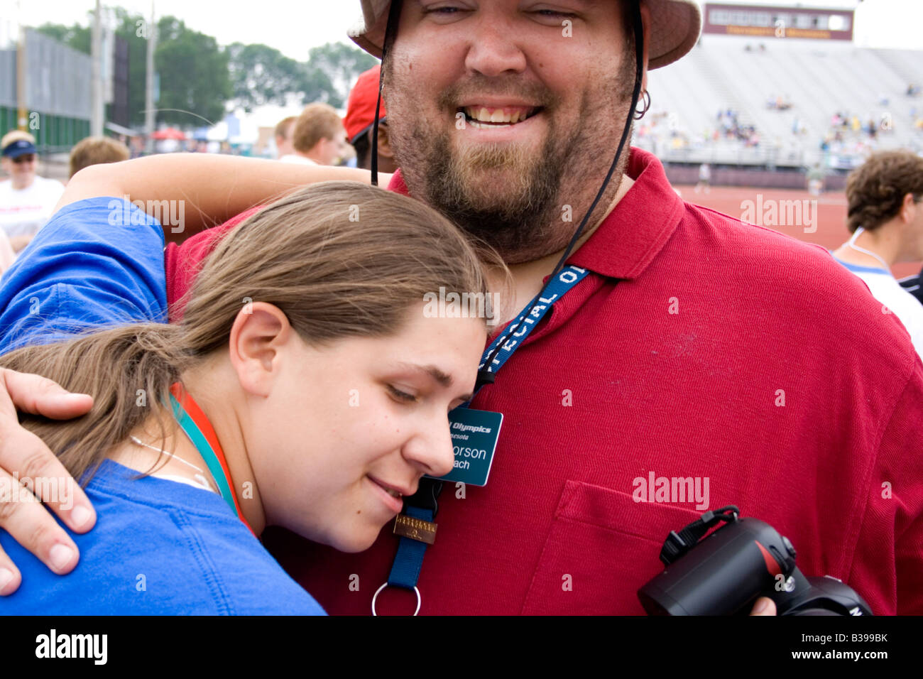 Coach and athlete enjoy victory at award ceremony. Special Olympics U