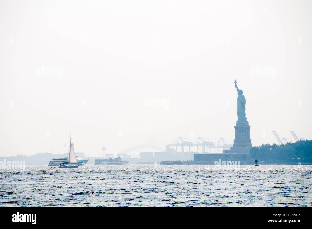 Statue of Liberty in the haze, looking from Battery Park on Manhattan Stock Photo