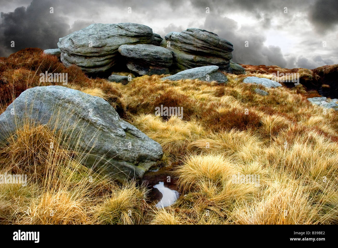 MOORLAND ROCKS WITH GREY CLOUDY SKY GRASSES Stock Photo