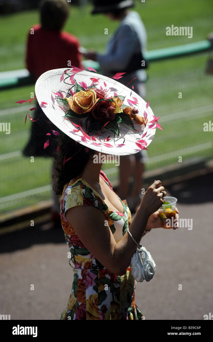 Lady wearing a wide hat enjoying a glass of Pimms at Brighton Races Ladies Day Stock Photo