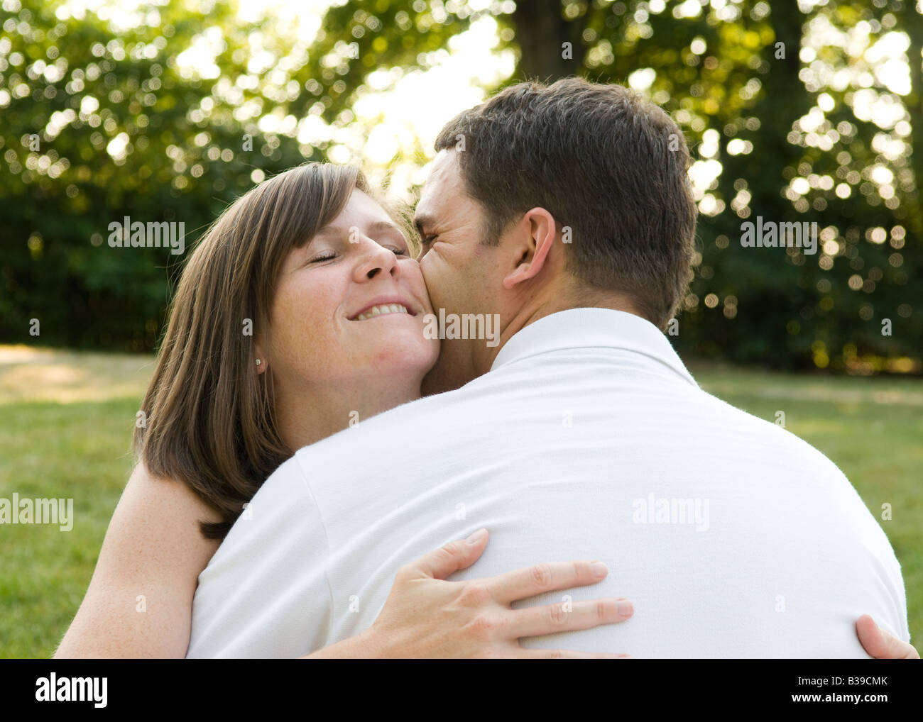 A loving couple kissing and hugging in the park Stock Photo - Alamy