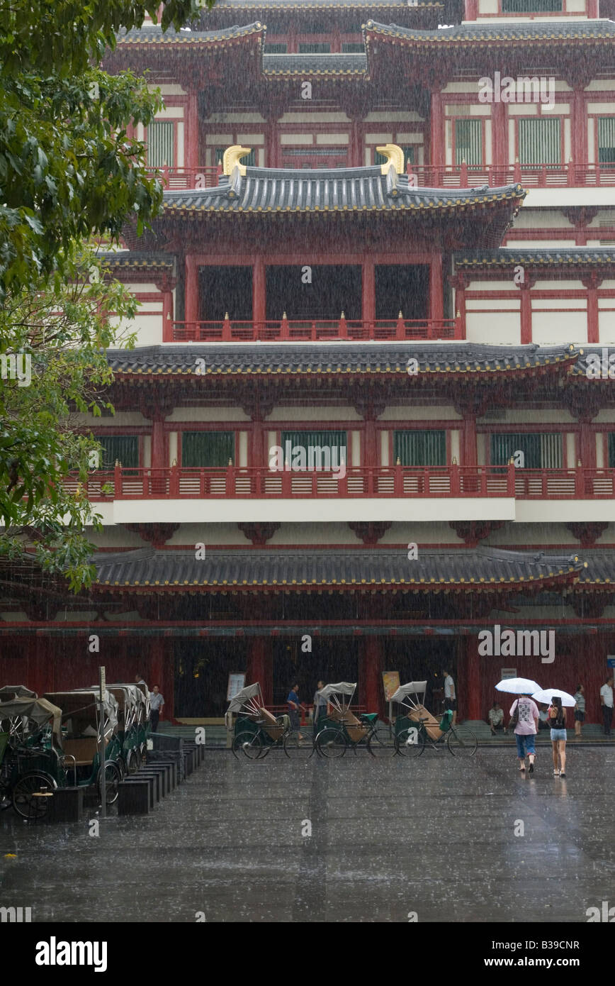 Tropical rain storm soaks parked trishaws at the Buddha Tooth Relic Temple, Chinatown, Singapore Stock Photo