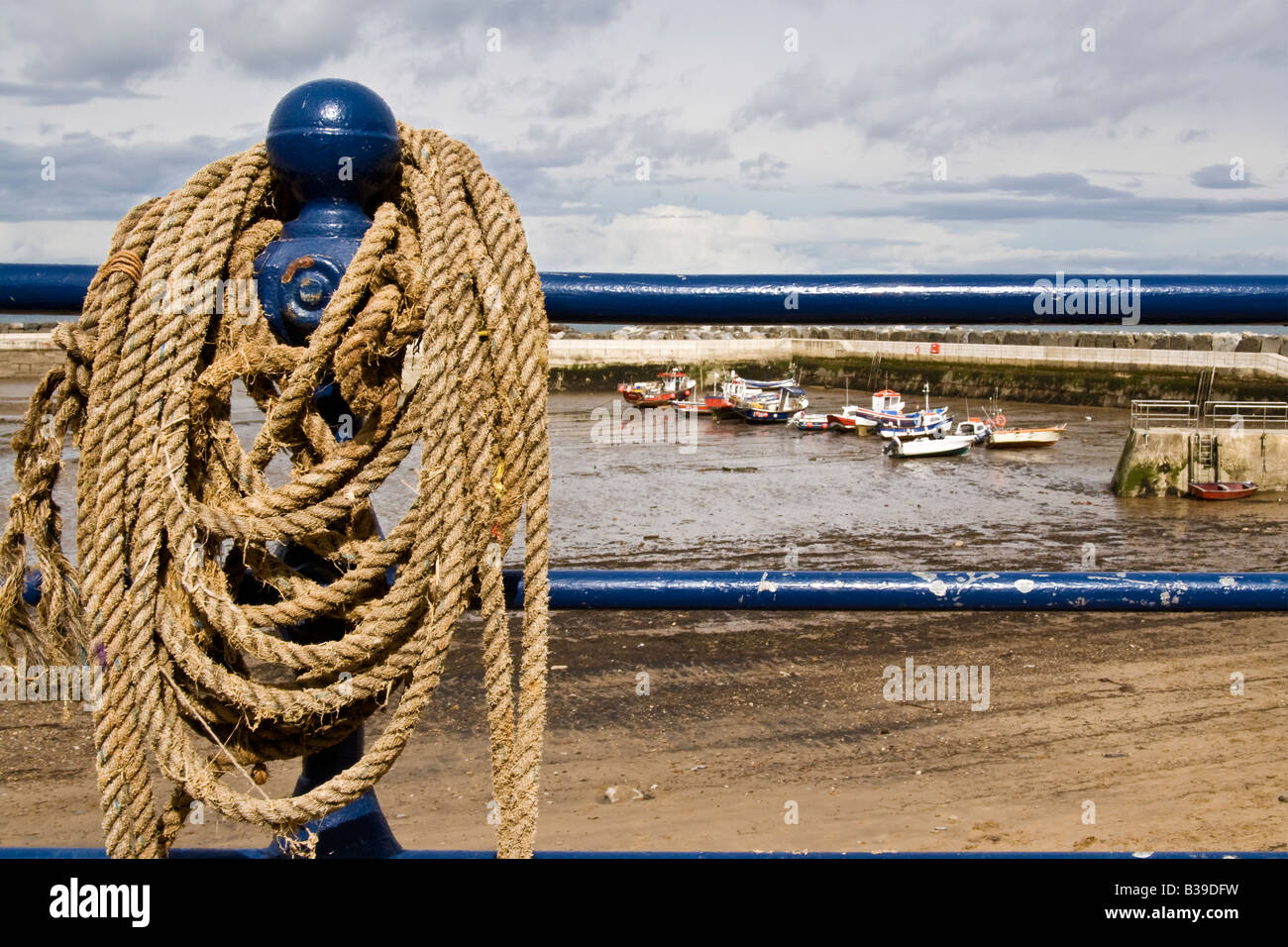 Rope coiled around railings at a harbour Stock Photo - Alamy