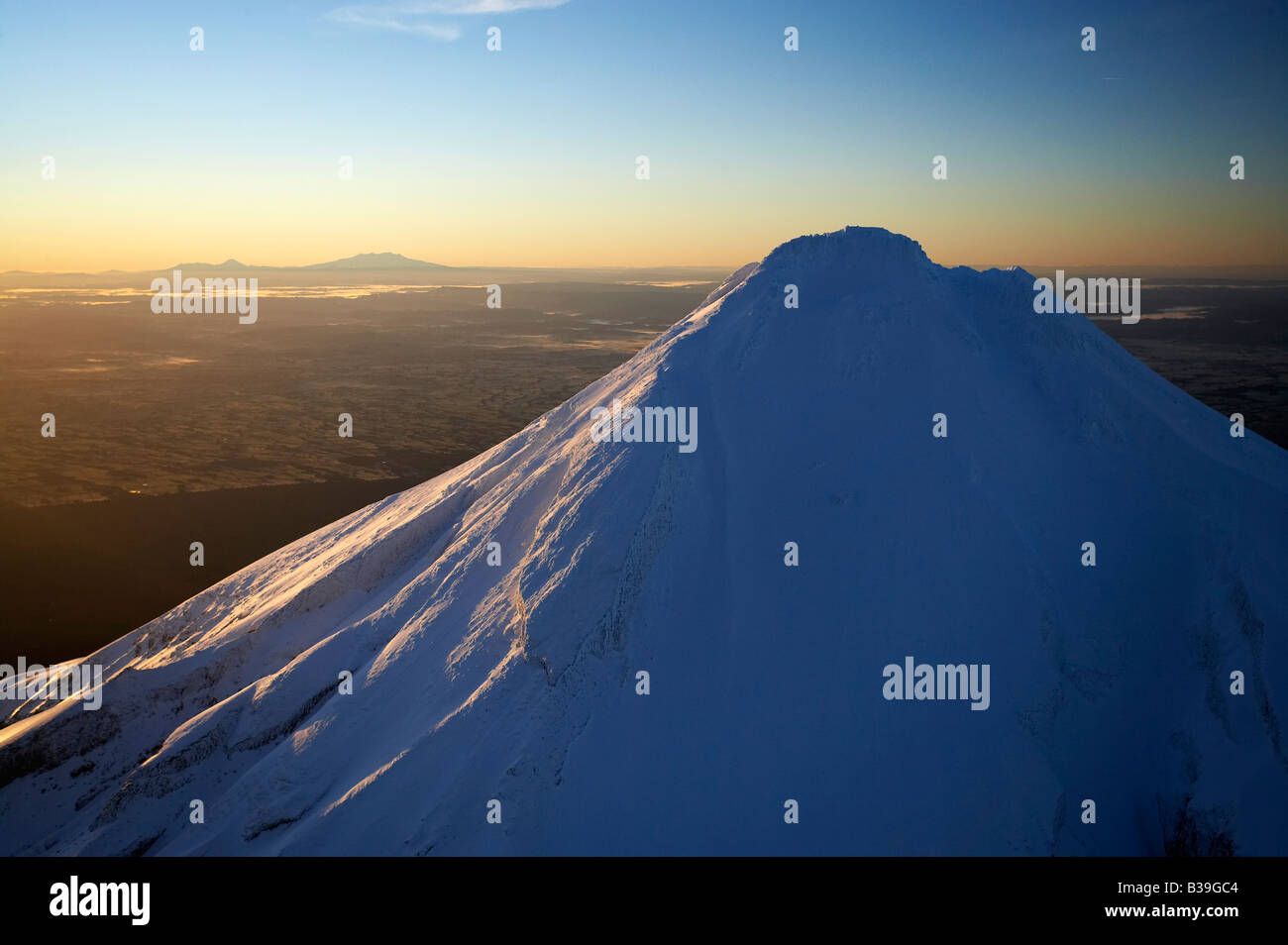 First Light on Summit of Mt Taranaki Mt Egmont with Mts Ngauruhoe and Ruapehu in the Far Distance North Island New Zealand Stock Photo