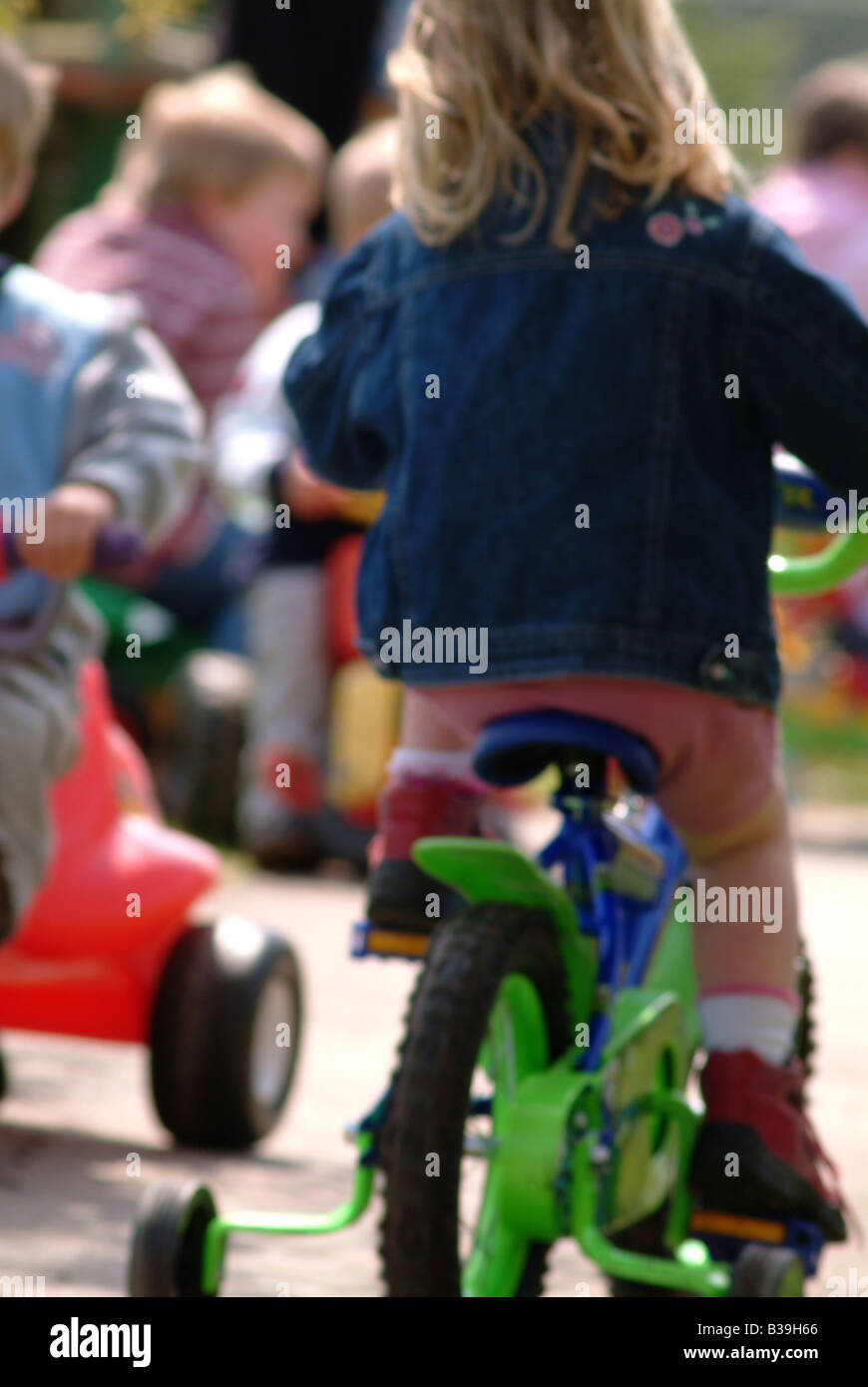 Nursery children riding on trikes and bikes Stock Photo