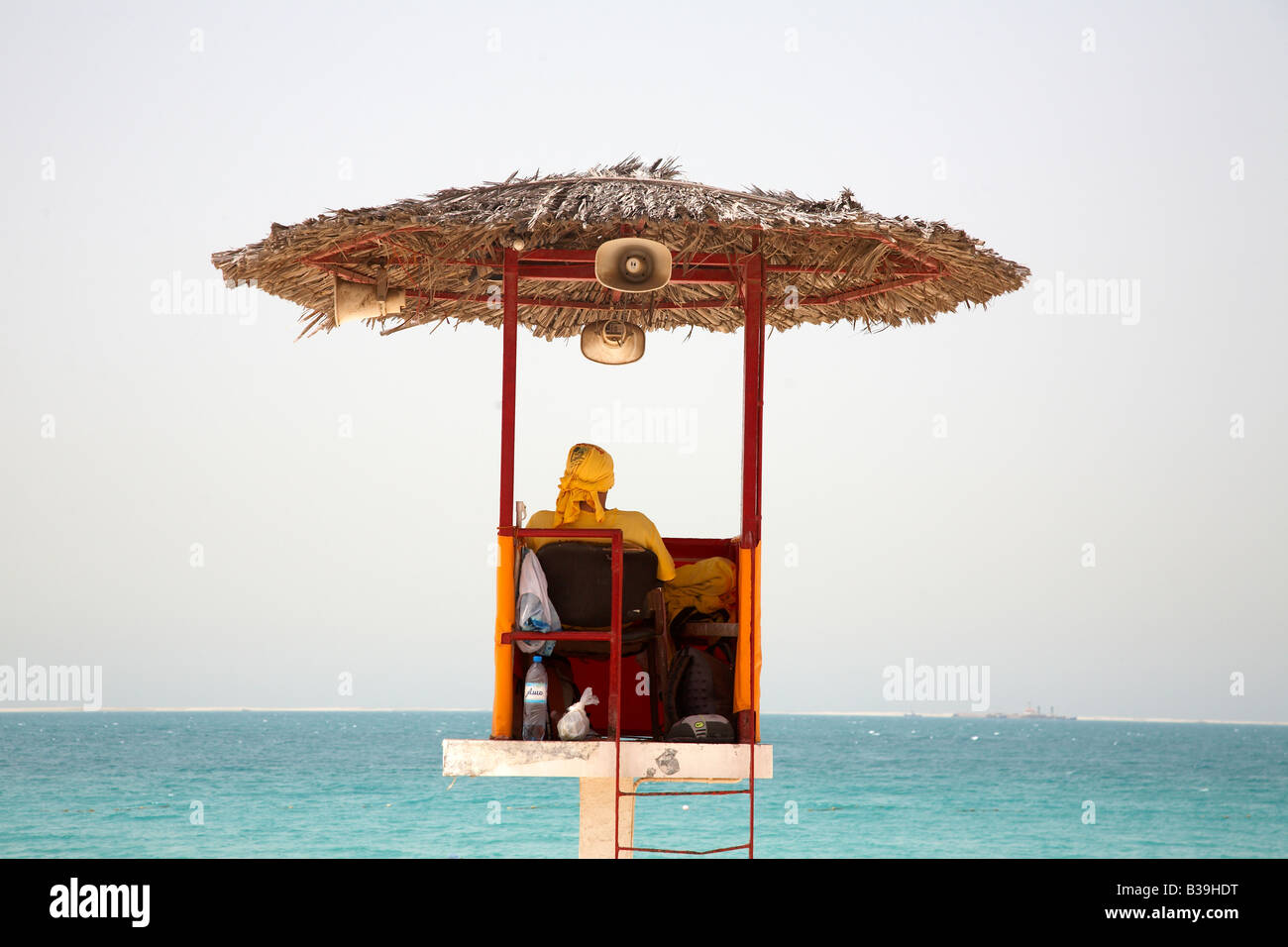 Life guard looking out across the sea from his watch tower at Jumeirah Beach Dubai Stock Photo