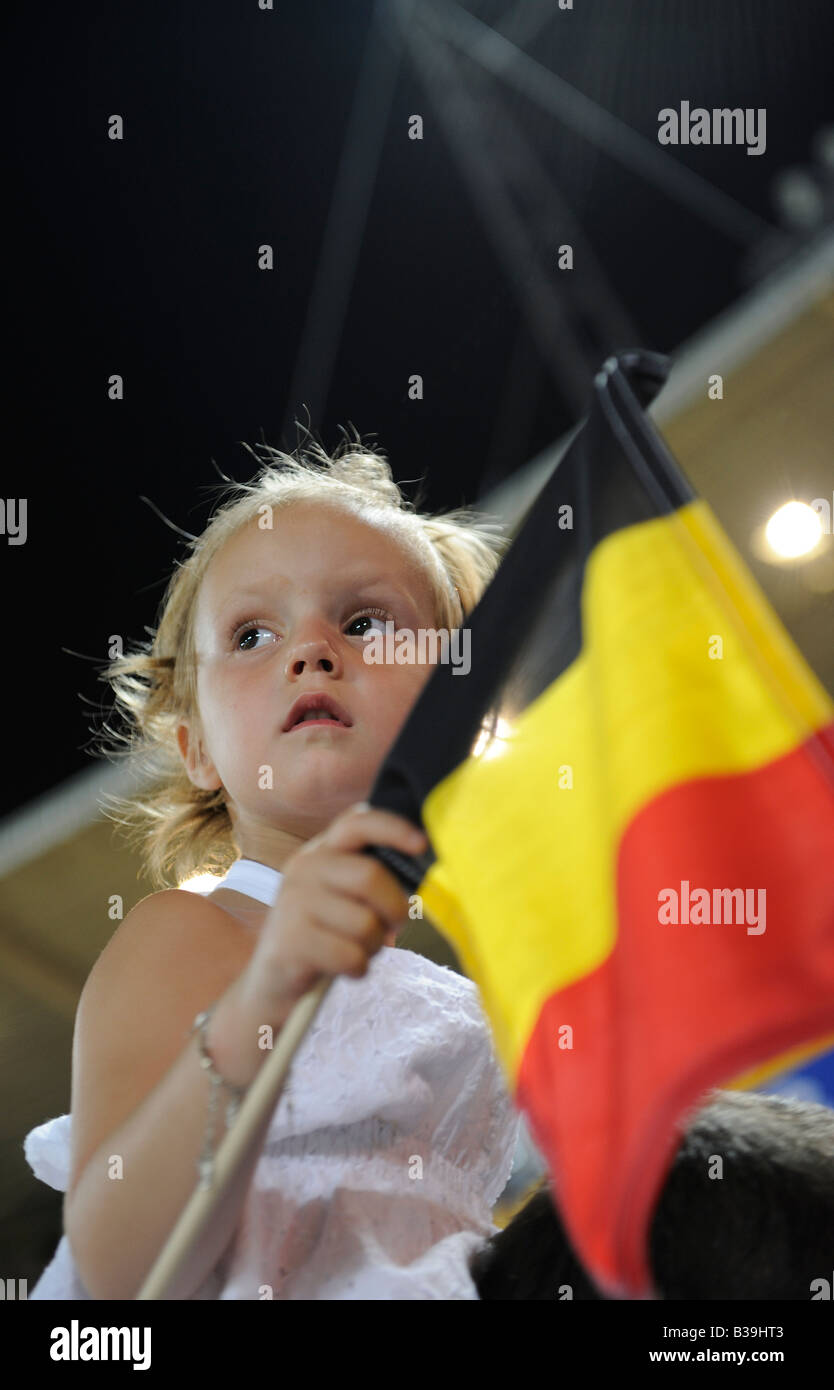 A girl holding the flag of Belgium during a football match between Belgium and Italy at the Beijing 2008 Olympic Games. Stock Photo