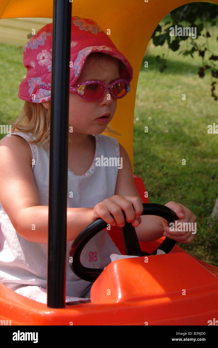 little girl driving toy car