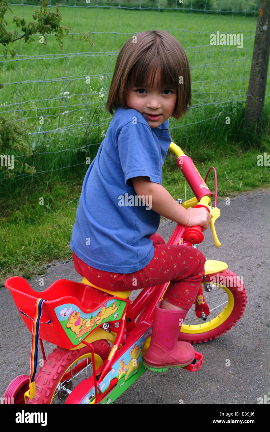 Portrait of a girl cycling with stabilisers Stock Photo