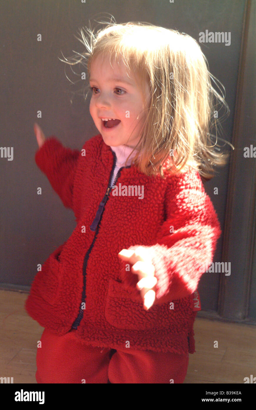 Smiling little girl wearing a red fleece jacket Stock Photo Alamy