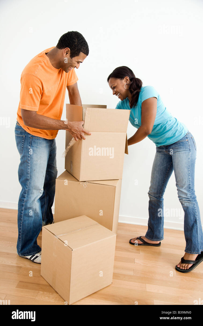 African American male and female couple packing cardboard boxes Stock Photo