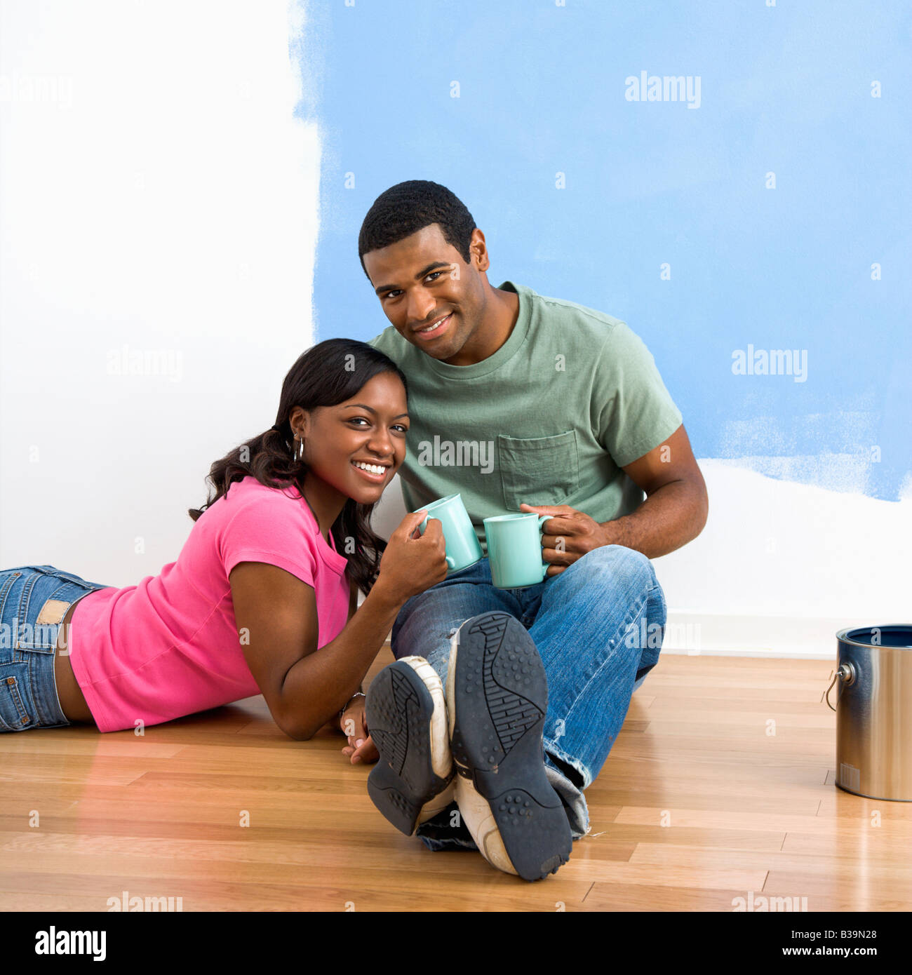 African American couple relaxing together with coffee next to half ...