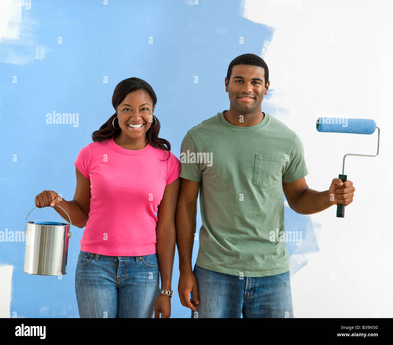 African American couple next to half painted wall with paint supplies American Gothic style Stock Photo