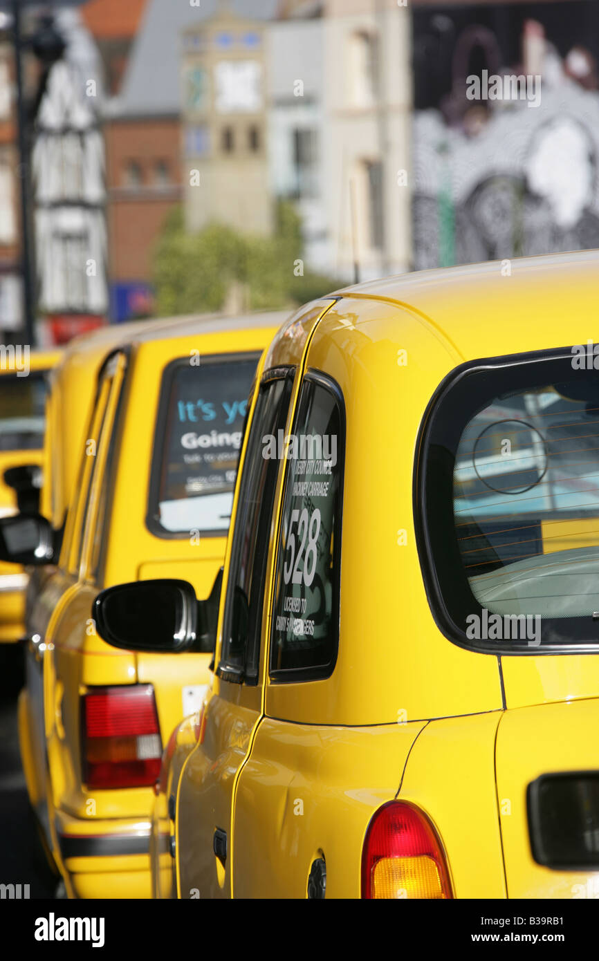 City of Derby, England. The distinctive AA Yellow coloured taxi Hackney Carriages parked on Derby’s Osmaston Road. Stock Photo