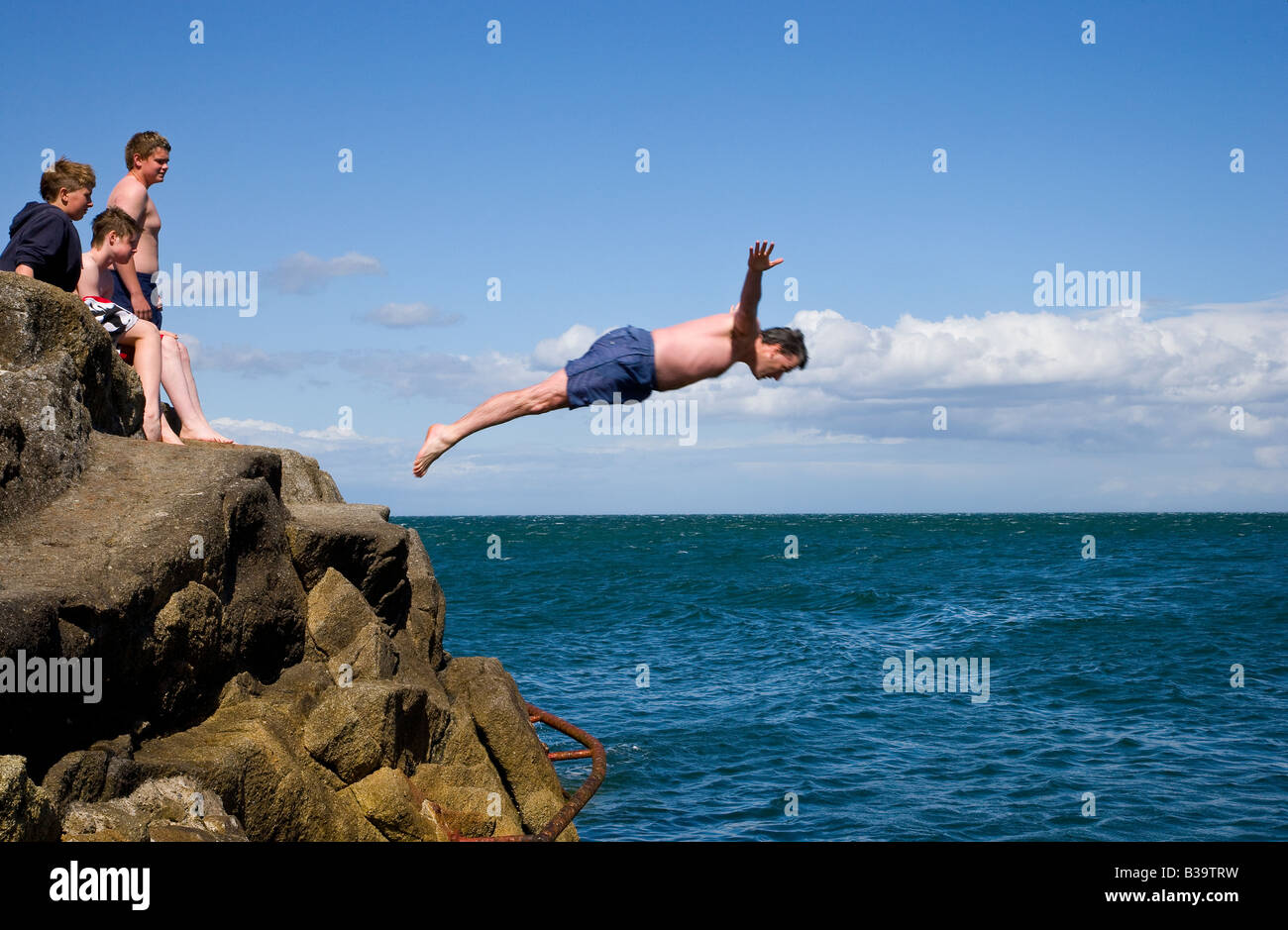 man diving into sea from rocks Stock Photo Alamy