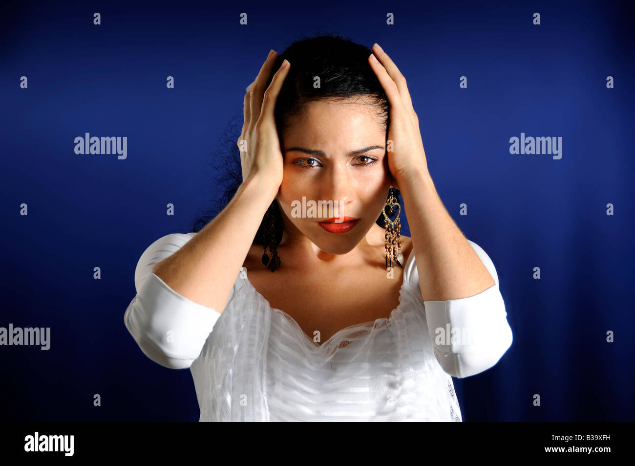 Portrait of serious hispanic woman with hands on the head Stock Photo