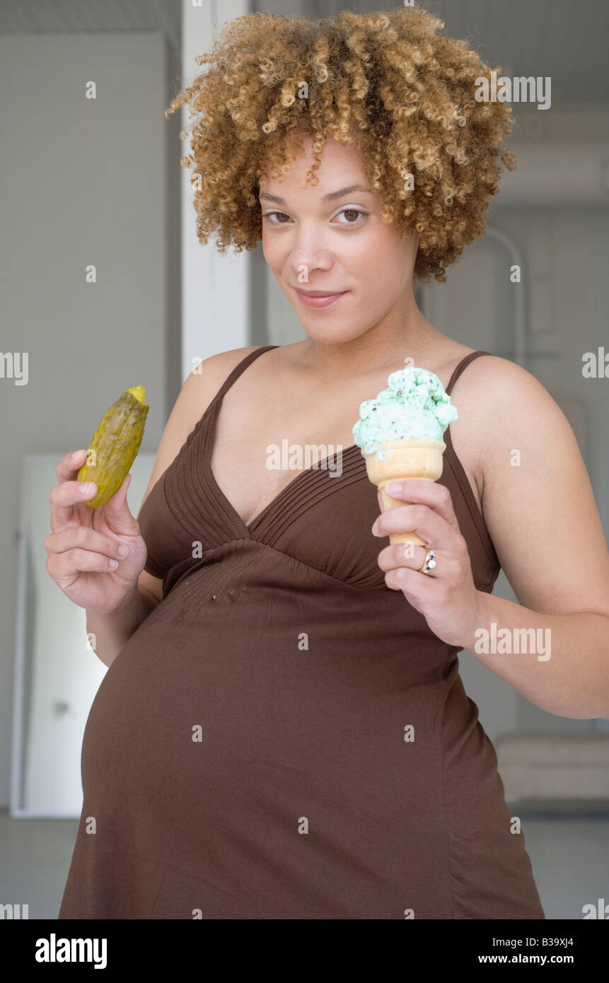 Pregnant African woman holding pickle and ice cream Stock Photo Alamy