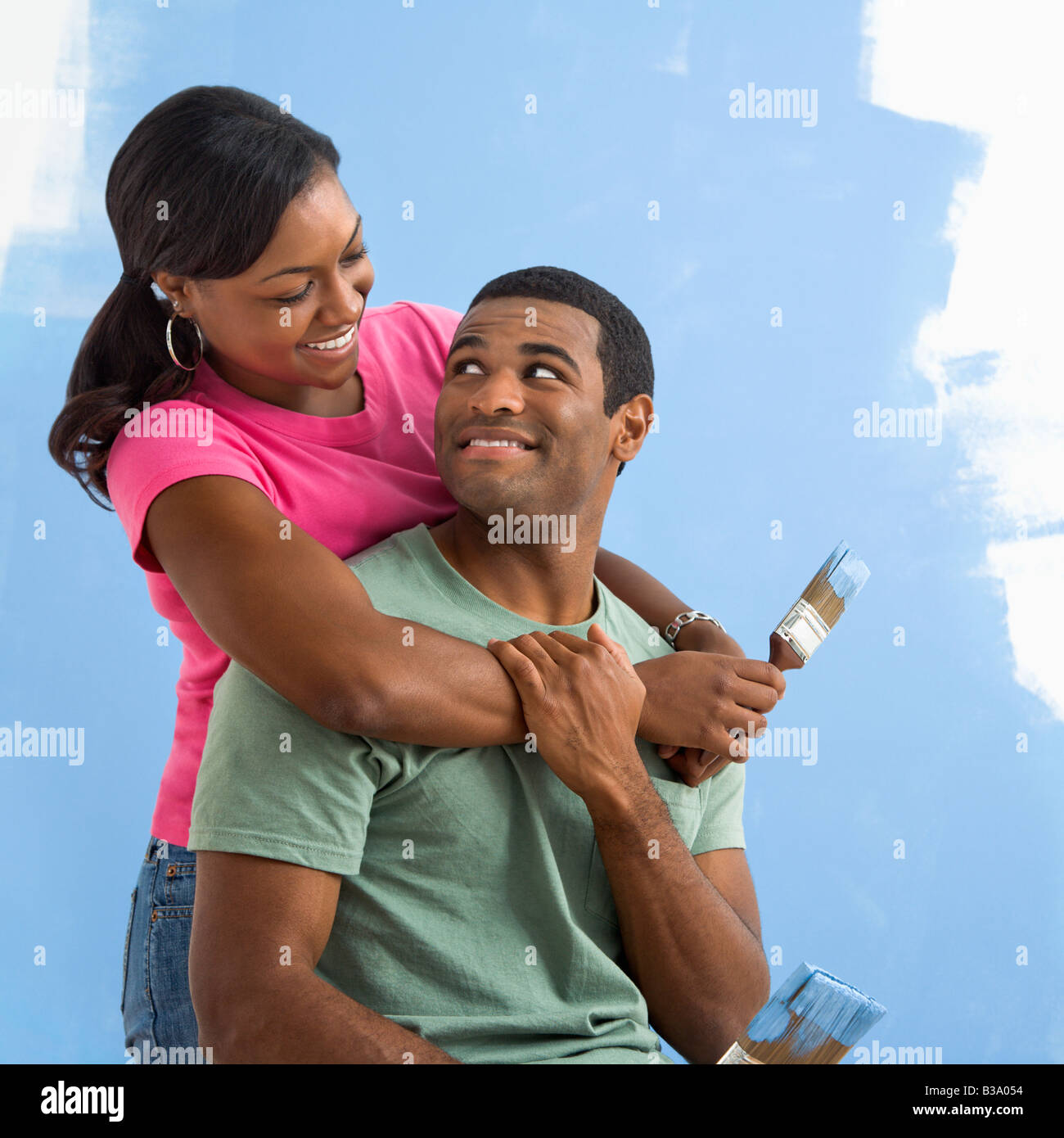 Portrait of African American male and female couple next to half painted wall Stock Photo
