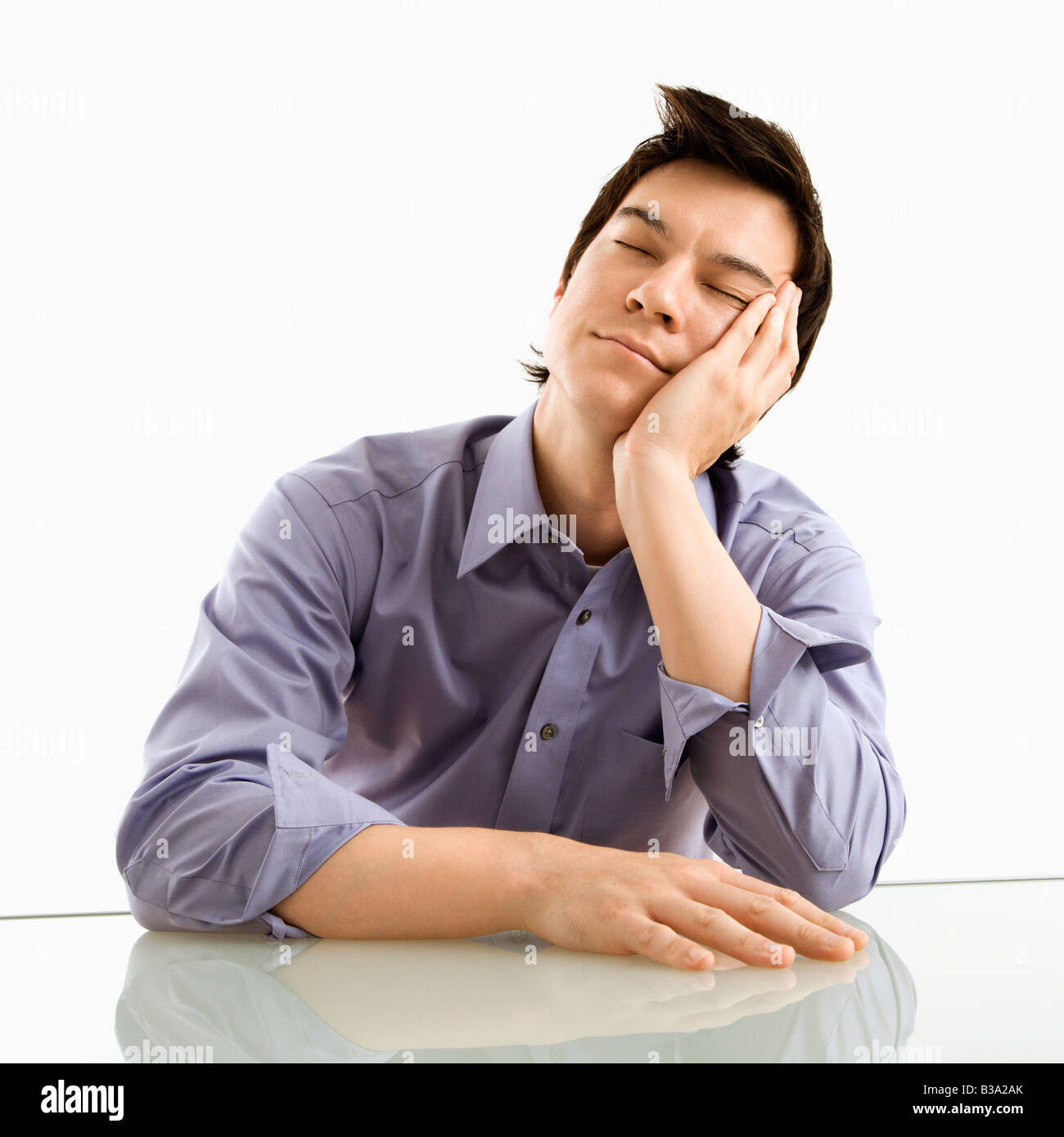 Young Asian business man sitting resting his eyes Stock Photo