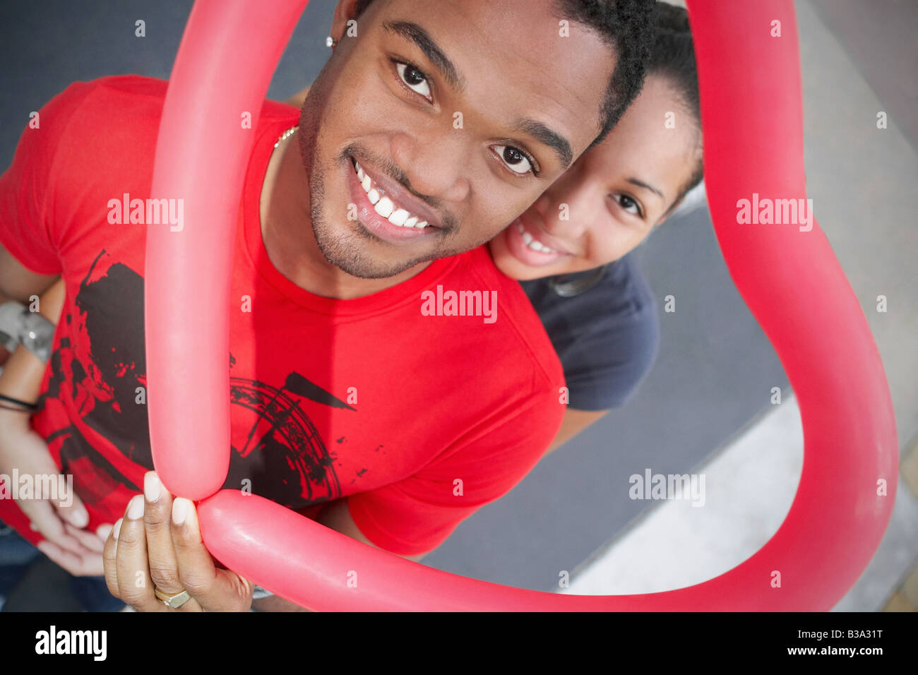 African couple holding heart-shaped balloon Stock Photo - Alamy