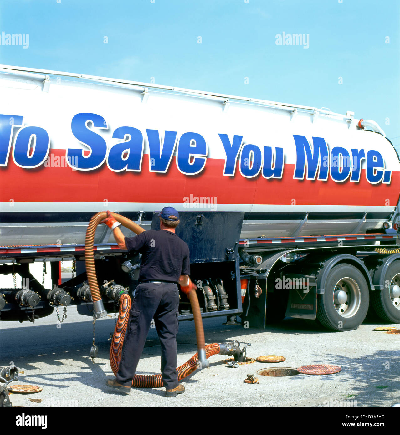 A fuel industry worker with a vapour removal pipe leading from a truck and tanker at a Pioneer gas station in Ontario, Canada Stock Photo