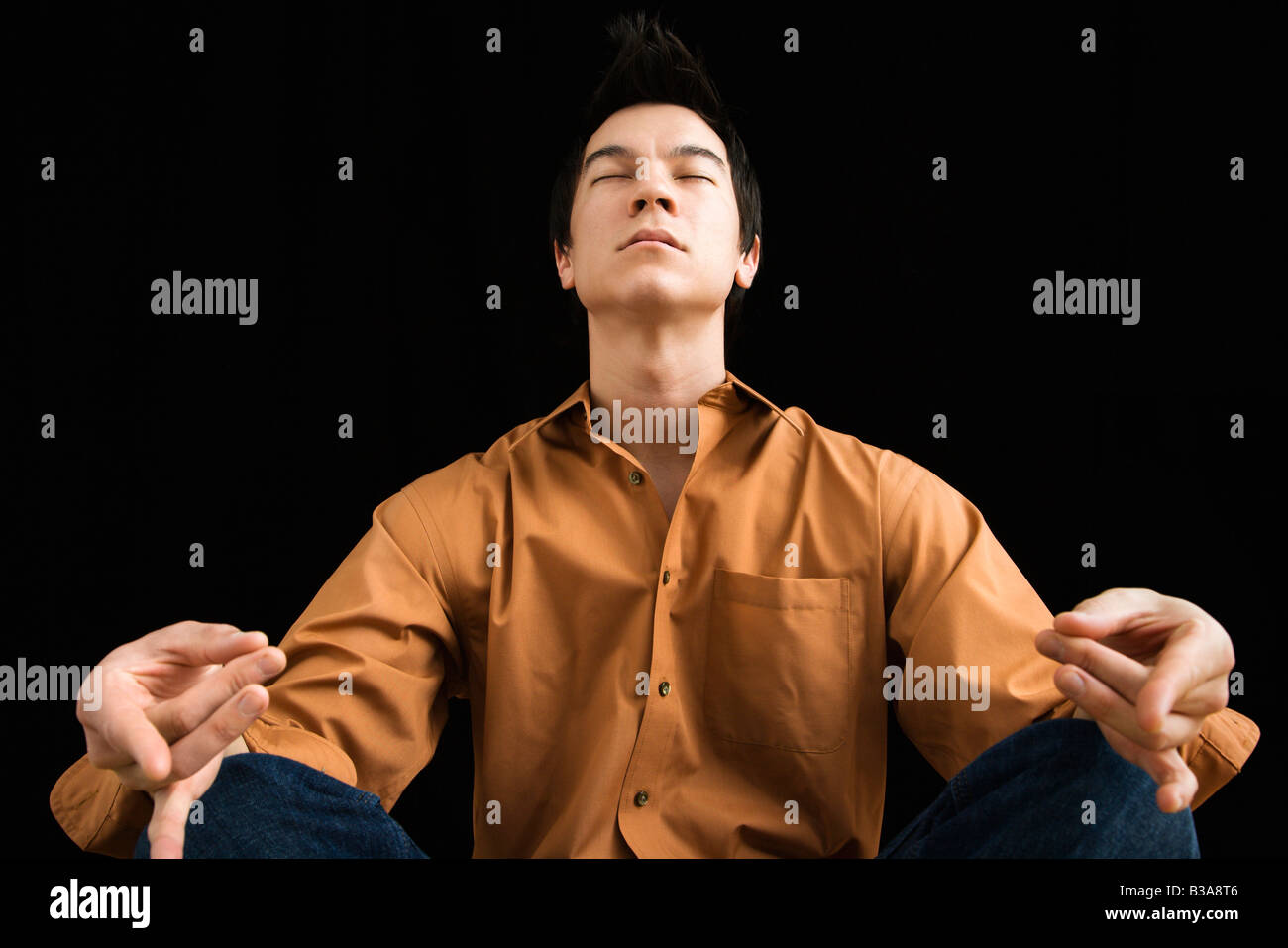 Asian young man sitting in meditative lotus position Stock Photo
