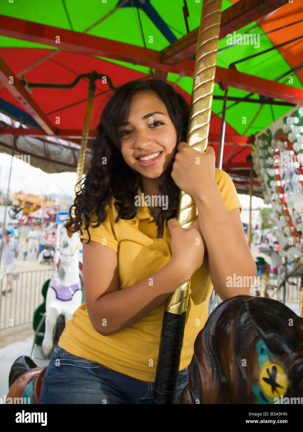 Mixed Race teenaged girl on carousel horse Stock Photo Alamy