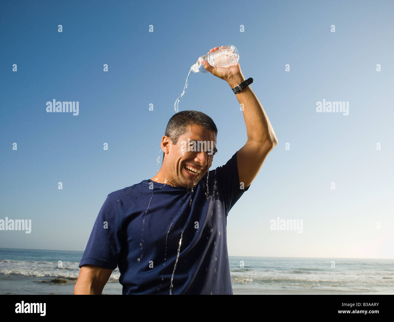 Hispanic man pouring water over head Stock Photo Alamy