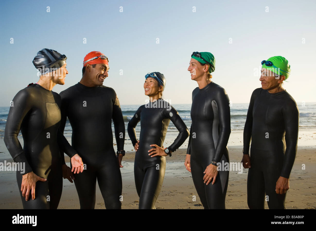 Multi-ethnic swimmers wearing wetsuits and goggles Stock Photo