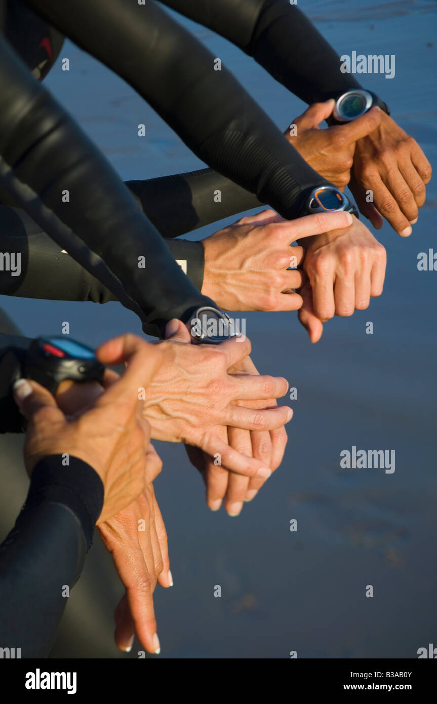 Multi-ethnic swimmers checking watches Stock Photo