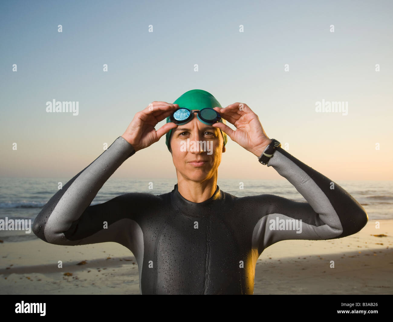 Hispanic woman wearing wetsuit and goggles Stock Photo