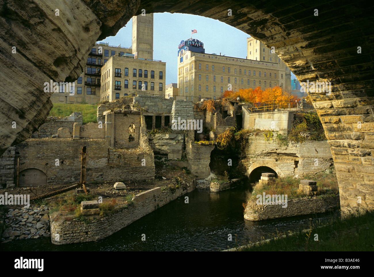 VIEW OF MILL RUINS PARK THROUGH STONE ARCH BRIDGE AND MISSISSIPPI RIVER IN DOWNTOWN MINNEAPOLIS, MINNESOTA.  FALL. Stock Photo