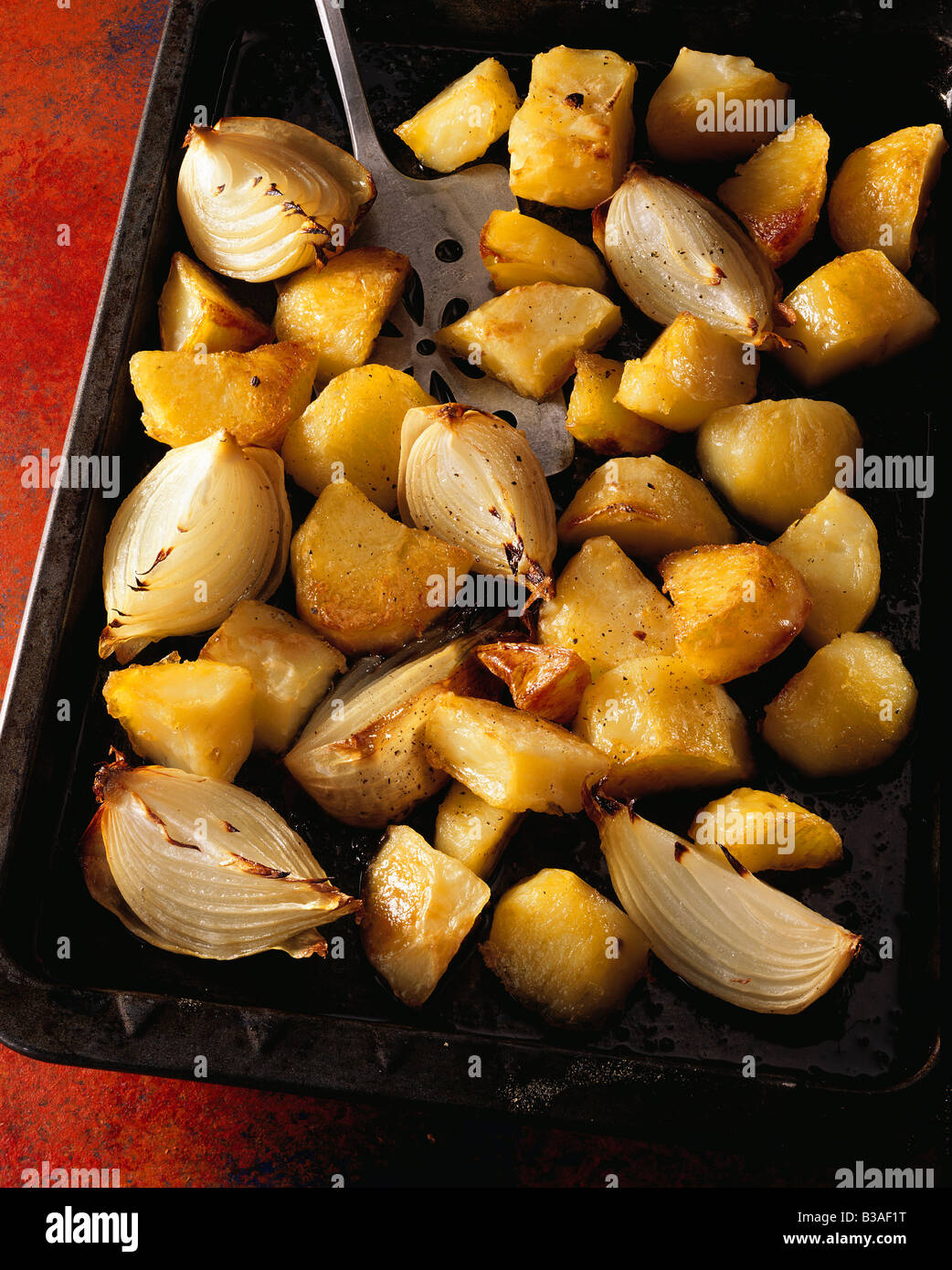 Roast potatoes and onions editorial food Stock Photo Alamy