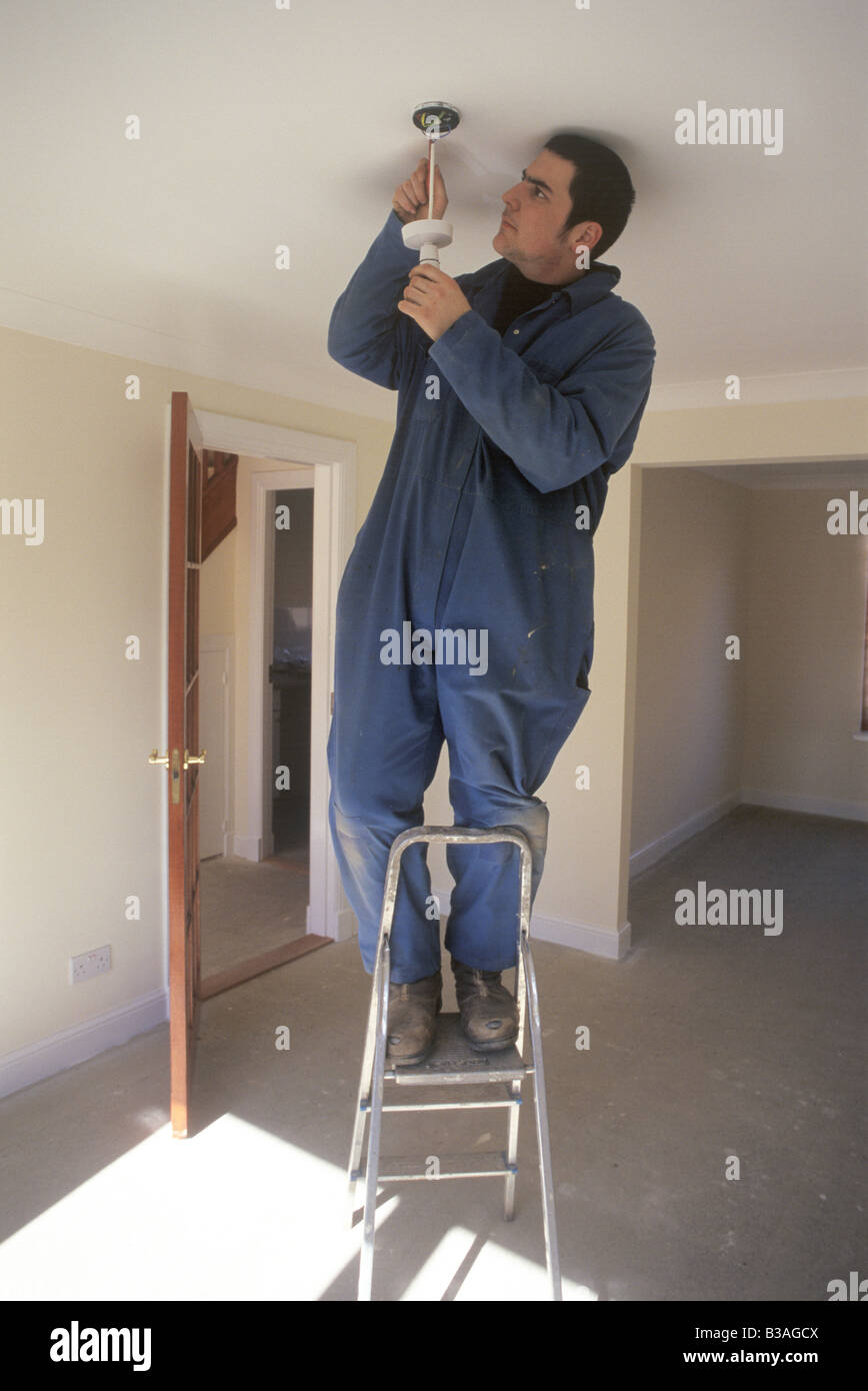 electrician wiring a ceiling rose Stock Photo