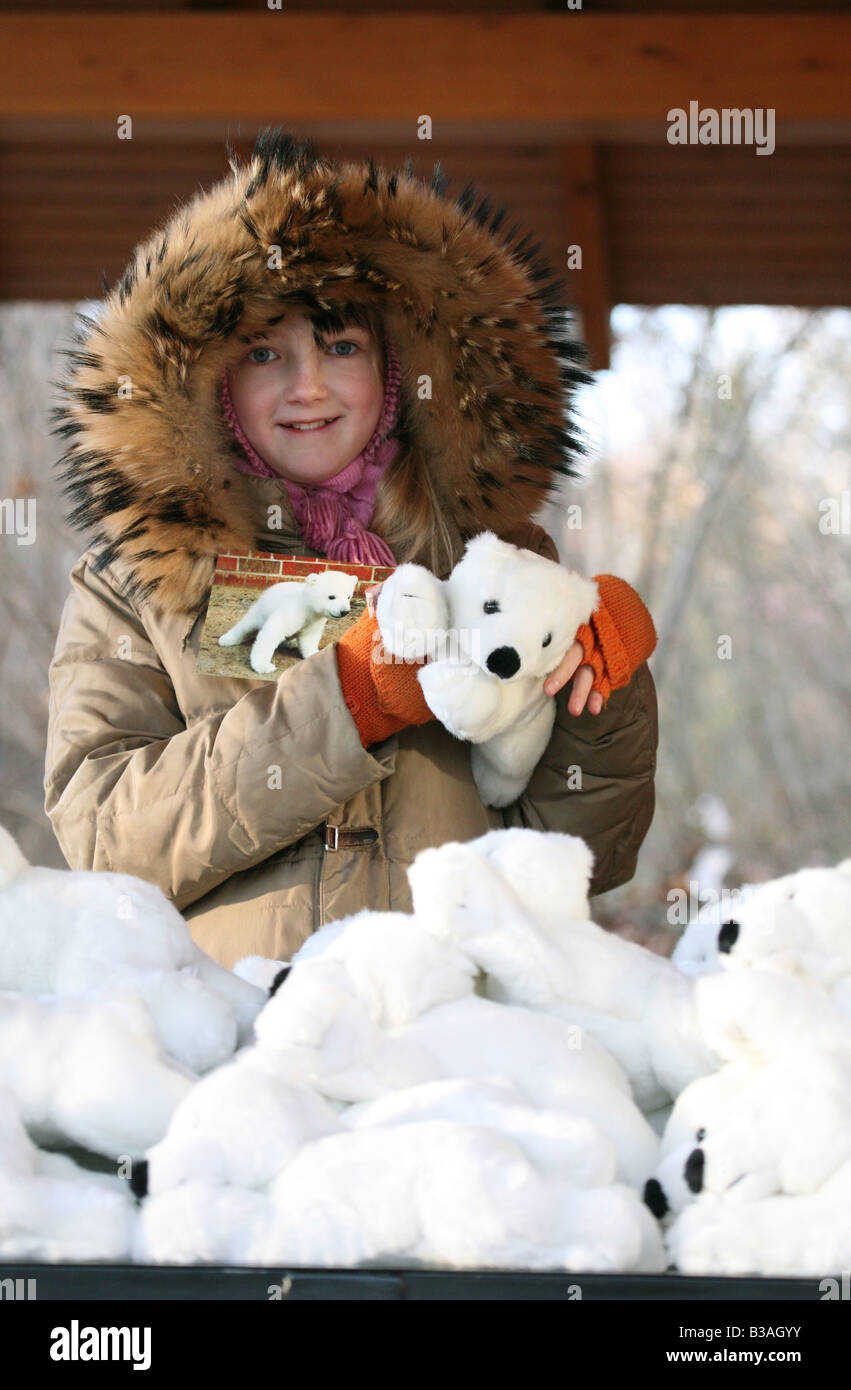 Young girl choosing a gift from the stack of Knut the polar bear toys the souvenir shop at Berlin Zoo, Germany Stock Photo