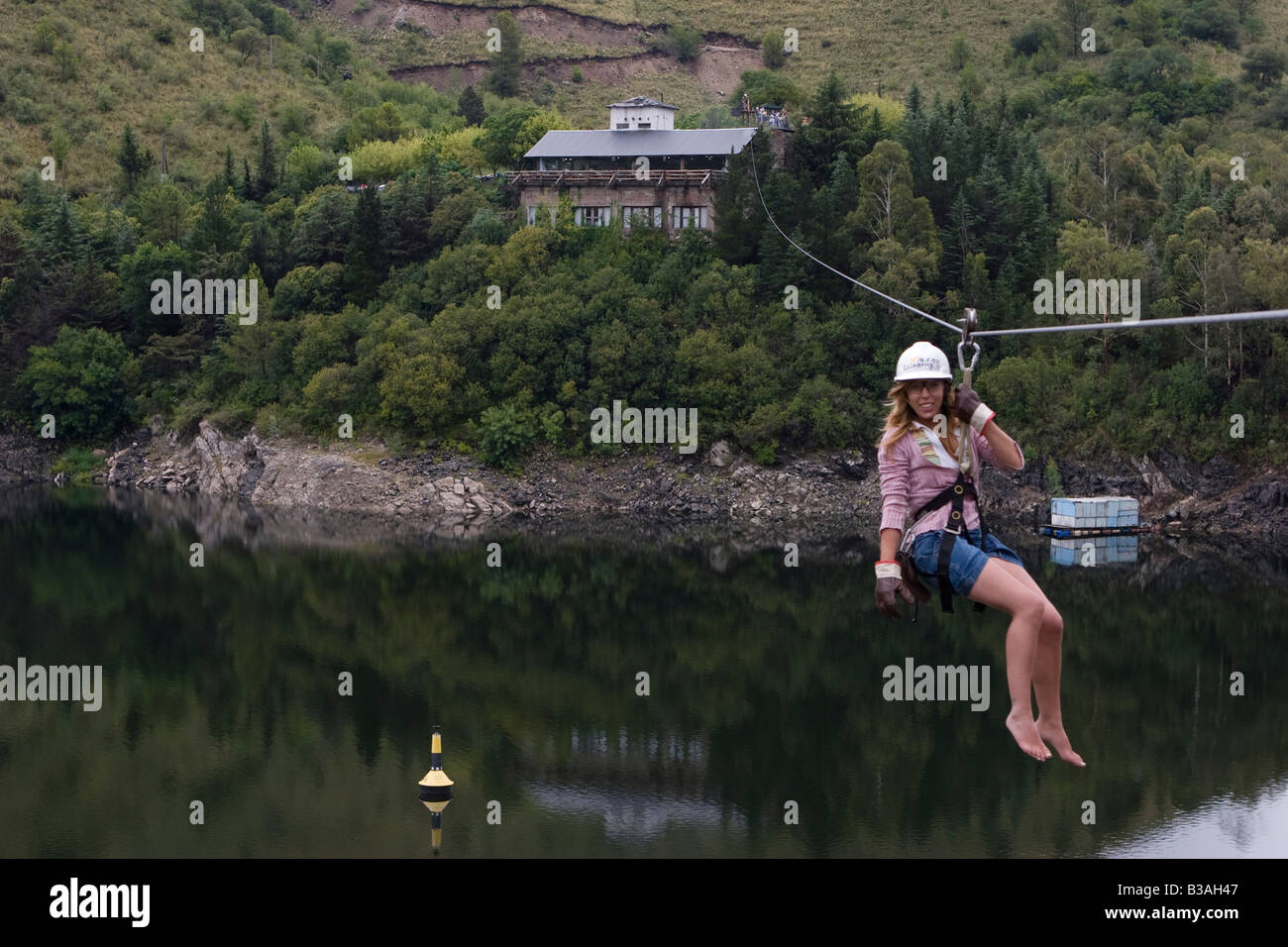 Female tourist doing canopy cable in Dique Los Molinos dam Cordoba ...