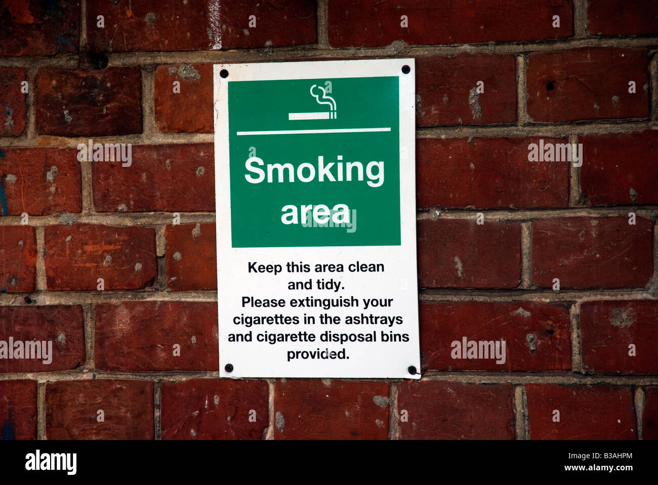 Smoking area notice sign on wall Stock Photo