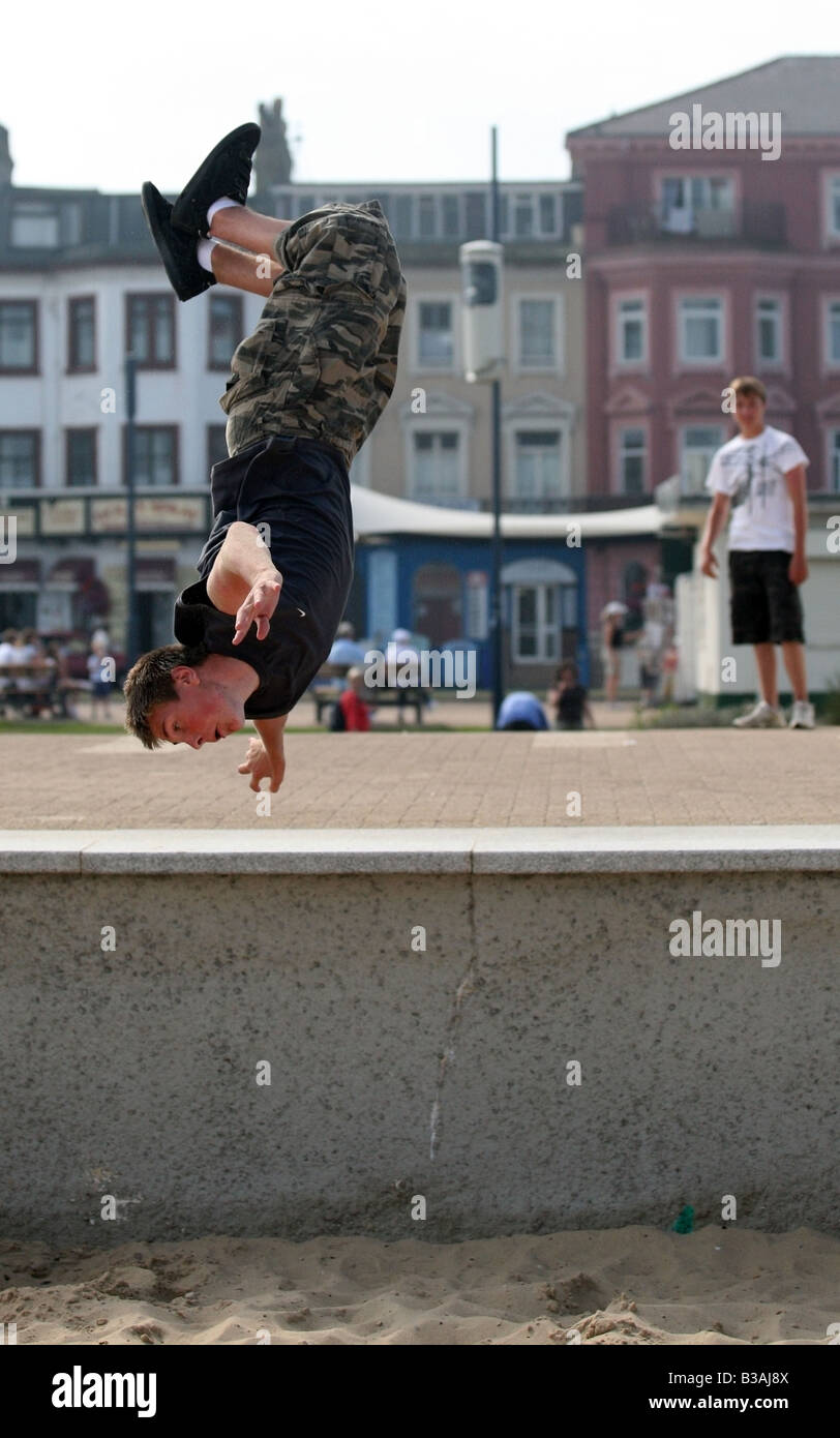 A 'free runner' somersaulting off the sea wall at Great Yarmouth, England Stock Photo