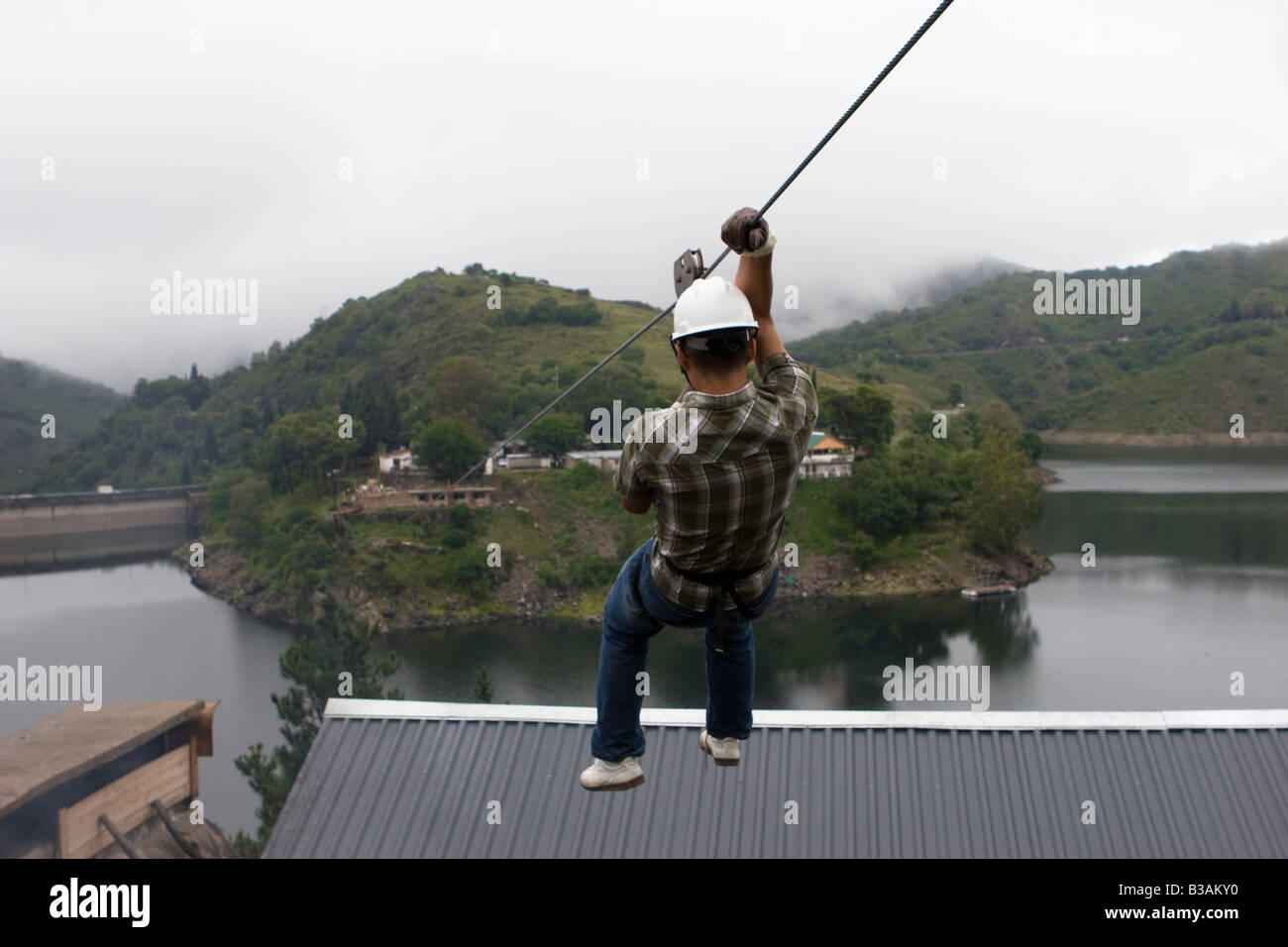 Tourist doing canopy cable in Dique Los Molinos dam Cordoba Argentina ...