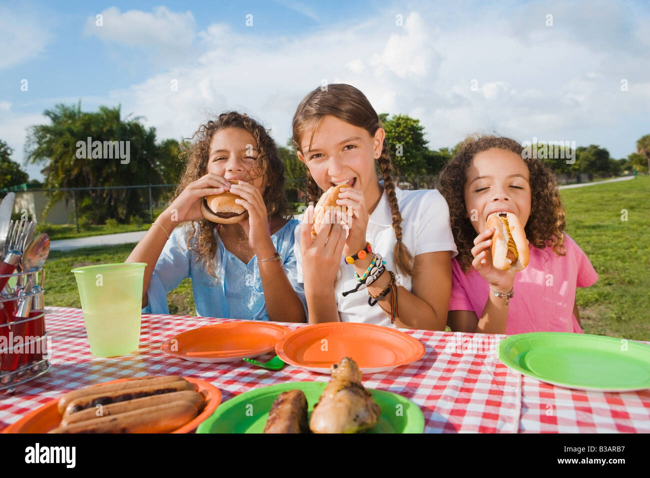 Hispanic girls eating at picnic table Stock Photo Alamy