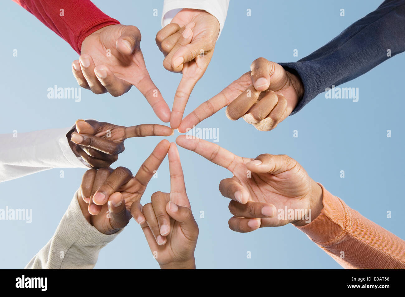 Multiethnic friends pointing fingers in circle Stock Photo Alamy
